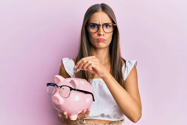 Mulher Hispânica Jovem Segurando Banco Porquinho Com Óculos Moeda Cético — Fotografia de Stock