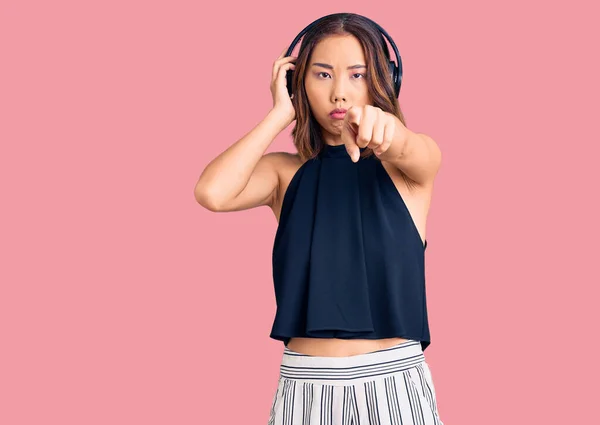 Menina Chinesa Bonita Nova Ouvindo Música Usando Fones Ouvido Apontando — Fotografia de Stock