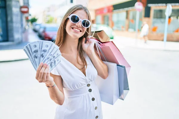 Jonge Blonde Vrouw Glimlachend Gelukkig Houden Boodschappentassen Dollars Bankbiljetten Straat — Stockfoto