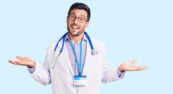 Jonge Spaanse Man Doktersuniform Stethoscoop Glimlachend Met Beide Handen Open — Stockfoto