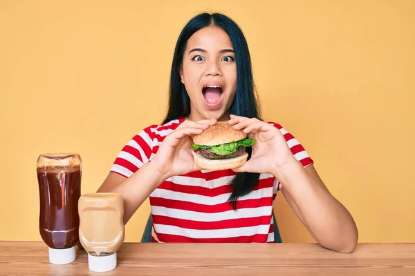 Fiatal Ázsiai Lány Eszik Egy Ízletes Klasszikus Burger Ünnepli Őrült — Stock Fotó