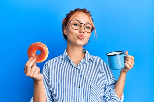 Joven Pelirroja Desayunando Sosteniendo Donut Chocolate Café Mirando Cámara Soplando —  Fotos de Stock