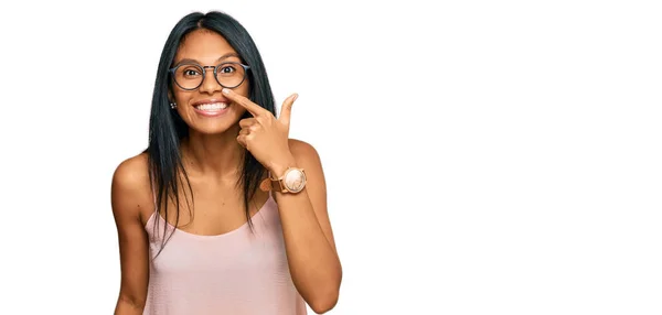若いアフリカ系アメリカ人の女性は 顔や鼻に手指で指差すカジュアルな服や眼鏡をかけて 陽気に笑っています 美の概念 — ストック写真