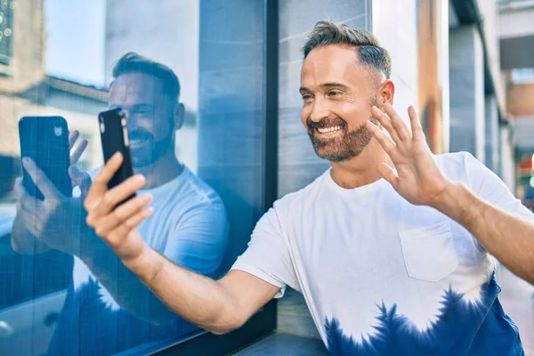 Homem Bonito Meia Idade Sorrindo Feliz Fazendo Videochamada Usando Smartphone — Fotografia de Stock