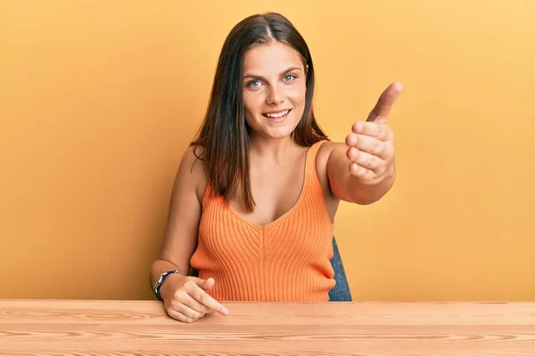 Mulher Caucasiana Jovem Vestindo Roupas Casuais Sentado Mesa Sorrindo Amigável — Fotografia de Stock