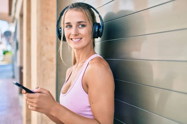 Junge Blonde Sportliche Mädchen Mit Smartphone Und Kopfhörer Lehnen Der — Stockfoto