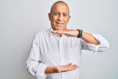 Yakışıklı, beyaz gömlek giyen, elleri büyük ve büyük boy işareti gösteren, ölçü sembolü olan bir adam. Kameraya bakıp gülümsüyor. ölçüm kavramı. 