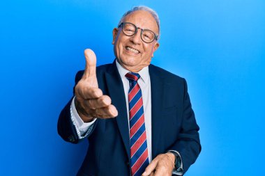 Beyaz üst düzey, takım elbiseli ve kravatlı, neşeli gülümseyen, yardım eli uzatan ve kabul gören bir adam.. 