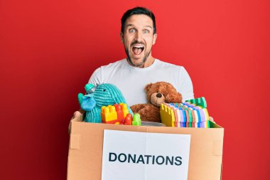 Genç ve yakışıklı bir adam bağış kutusunu oyuncaklarla doldurdu. Çılgınca ve hayret verici bir başarıyı kutluyorlar. Gözleri açık, heyecanlı çığlıklar atıyorlar.. 