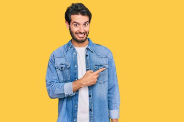 Gündelik kıyafetler giyen genç İspanyol adam endişeli ve gergin bir şekilde işaret ediyor. 