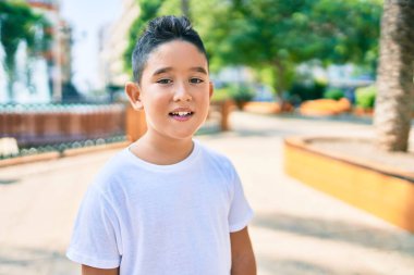 Sevimli çocuk gülümsüyor Şehrin caddesinde mutlu bir şekilde duruyor.