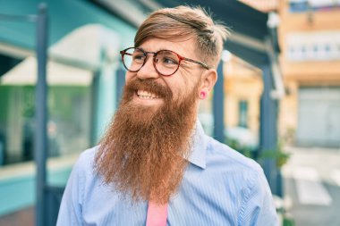 Uzun sakallı, genç, kızıl saçlı işadamı şehire doğru mutlu adımlarla yürüyordu..