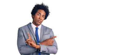 Afro saçlı, iş ceketi giyen yakışıklı Afro-Amerikalı iki tarafı da parmaklarıyla işaret ediyor. Farklı yönler farklı. 