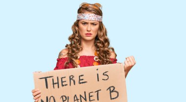 Hippi tarzı giyinmiş genç bir kız elinde B gezegeninin pankartı yok öfkeyle bağırıyor, öfkeyle bağırıyor ve el kaldırıyor. 