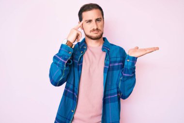 Gündelik giysiler giyen genç yakışıklı adam avuç içi açık fotokopi alanı ve alnını göstermekten rahatsız oluyor. Bunu bir düşün.. 