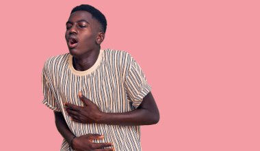 Afro-Amerikalı genç bir adam, hazımsızlık, acı verici bir hastalık ve midesi üzerine gündelik giysiler giyiyor. Ağrı kavramı. 