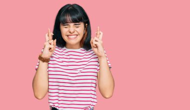 Günlük kıyafetler giyen genç İspanyol kız umut ve gözlerin kapalı gülümseyerek bana işaret etti. Şans ve batıl inançlar. 