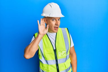 Orta yaşlı kel bir adam, mimar şapkası takmış, ağzı kulaklarına varan bir gülümsemeyle dedikodu ya da dedikoduları dinliyor. Sağırlık kavramı. 