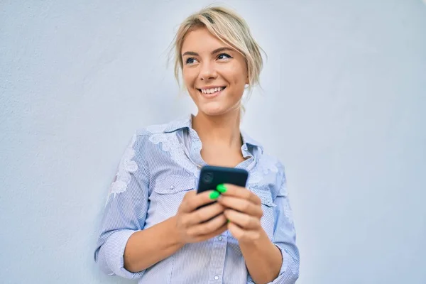 Mujer Rubia Joven Sonriendo Feliz Usando Teléfono Inteligente Ciudad —  Fotos de Stock