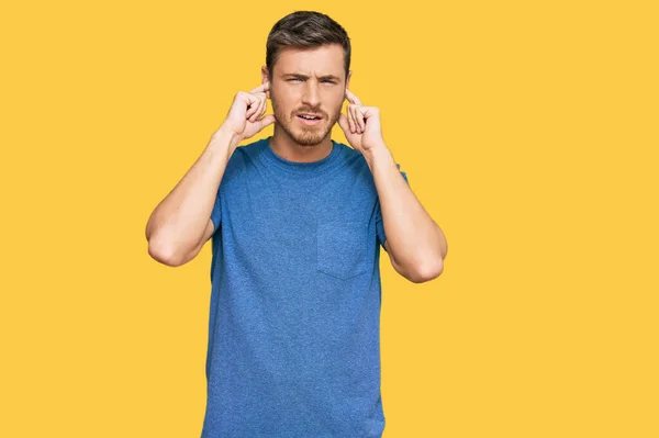 騒々しい音楽のノイズのためにいらいらする表情で指で耳を覆うカジュアルな服を着たハンサムな原因者 聴覚障害の概念 — ストック写真