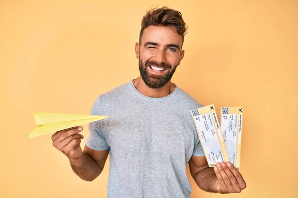 Joven Hispano Sosteniendo Avión Papel Tarjeta Embarque Guiñando Ojo Mirando — Foto de Stock