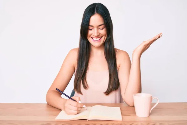 Jovem Caucasiana Sentada Mesa Escrevendo Livro Bebendo Café Celebrando Vitória — Fotografia de Stock