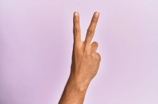 考卡年轻人的胳膊和手放在粉色孤立的背景上 数着2个手指 这预示着胜利和胜利的象征 — 图库照片