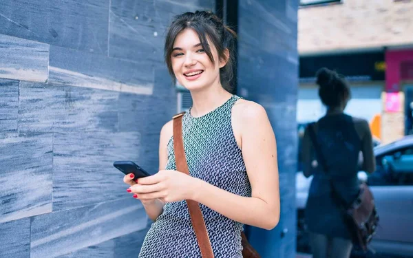 年轻的高加索女商人在城市里用智能手机开心地微笑着 — 图库照片