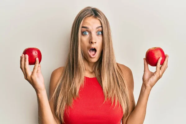 Ung Blond Kvinna Håller Röda Äpplen Rädda Och Chockad Med — Stockfoto