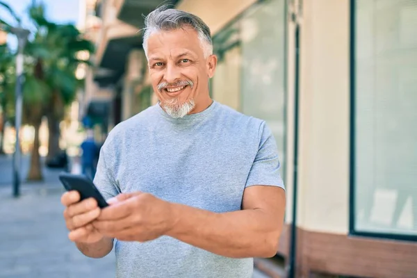 Středověký Hispánský Šedovlasý Muž Šťastně Usmívá Pomocí Smartphonu Městě — Stock fotografie