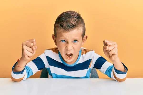 Adorable Niño Caucásico Con Ropa Casual Sentado Mesa Enojado Loco — Foto de Stock