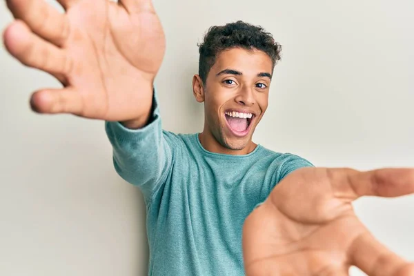 若いハンサムなアフリカ系アメリカ人の男性は 抱擁のために開いて腕を笑顔カメラを見てカジュアルな服を着ている 幸せを受け入れる陽気な表情 — ストック写真