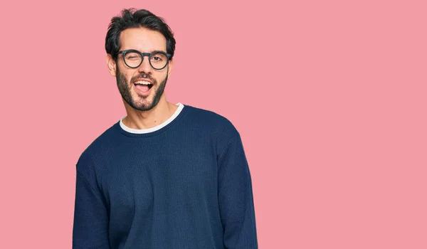 Young hispanic man wearing casual clothes and glasses winking looking at the camera with sexy expression, cheerful and happy face. — Stock Image Young Hispanic Man Wearing Casual Clothes Glasses Winking Looking Camera Royalty Free Stock Images