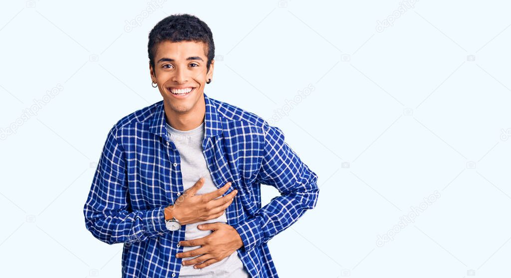 Young african amercian man wearing casual clothes smiling and laughing hard out loud because funny crazy joke with hands on body. 