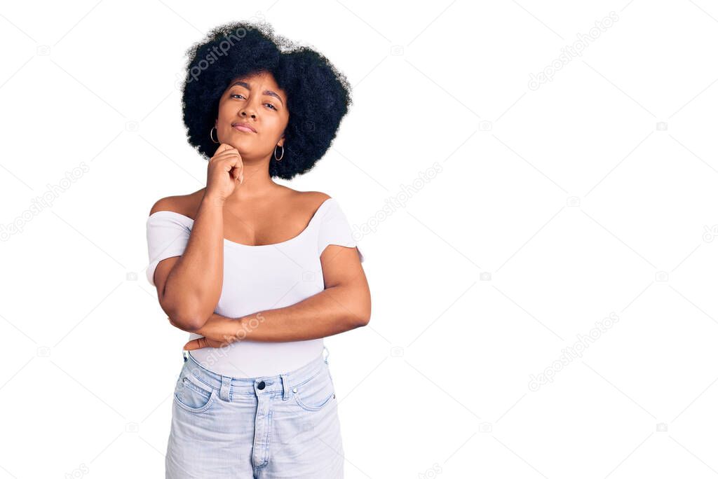 Young african american girl wearing casual clothes serious face thinking about question with hand on chin, thoughtful about confusing idea 