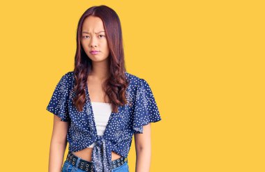 Gündelik kıyafetler giyen genç, güzel Çinli kız şüpheci ve gergin, sorun yüzünden surat asıyor. negatif kişi. 