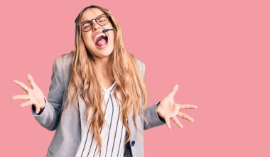 Çağrı merkezi kulaklığı takan genç, sarışın bir kadın. Deli gibi bağırıyor, bağırıyor, agresif bir ifade ve kollarla bağırıyor. hüsran kavramı. 