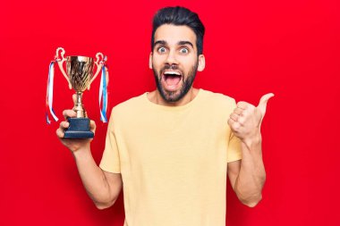 Sakallı, sakallı, genç, yakışıklı ve ağzı açık bir şekilde gülümseyen bir adam. 