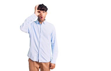 Latin asıllı genç bir adam normal giyiniyor. Şaşırmış yüz ifadesiyle şok olmuş, parmaklarından bakan gözler. İnançsız ifade. 