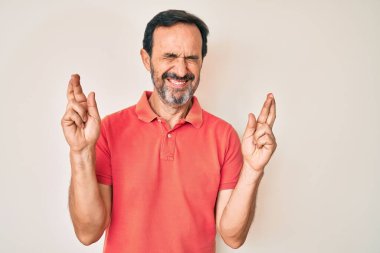 Orta yaşlı İspanyol bir adam gündelik kıyafetler giyip umut ve gözlerin kapalı gülümseyerek el sallıyor. Şans ve batıl inançlar. 