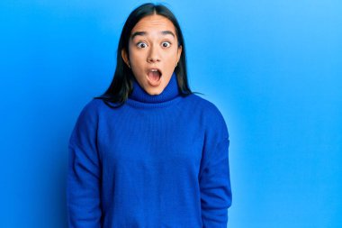 Kış süveteri giyen genç Asyalı kadın şaşkınlık ve şaşkınlık dolu bir ifade, korku ve heyecan dolu bir yüz ifadesiyle dehşete düşmüş ve şok olmuştu.. 