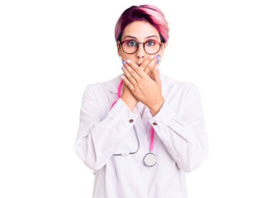 Pembe saçlı, doktor üniforması giyen genç ve güzel bir kadın yanlışlıkla ağızlarını kapatarak şok geçirdi. gizli kavram. 