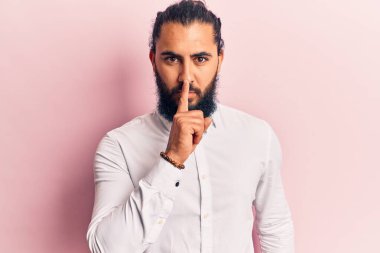 Gündelik giysiler giyen genç bir Arap dudaklarında parmaklarıyla sessiz olmak istiyor. sessizlik ve gizli konsept. 