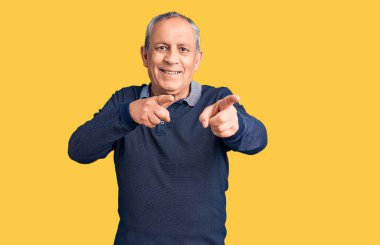 Kıdemli yakışıklı adam polo giyip mutlu ve komik yüzüyle kamerayı işaret ediyor. iyi enerji ve titreşimler. 