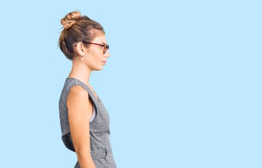 Sarı saçlı, iş kıyafetleri ve gözlükleri takan, rahat bir görünüm takınan, kendine güvenen, güzel beyaz bir kadın.. 