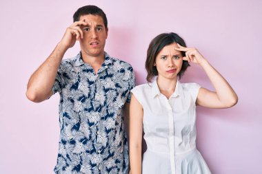 Gündelik giysiler giyen güzel bir çift. Alnındaki sorun yüzünden endişeli ve stresli. Gergin ve bunalımda. 