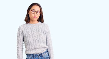 Genç, güzel Çinli kız rahat kıyafetler giyiyor. Uykulu ve yorgun görünüyor. Yorgunluktan bitkin düşmüş, akşamdan kalma, tembel gözlü.. 