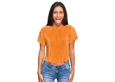 Genç, esmer, Arap bir kadın. Günlük kıyafetler giyiyor. Dilini komik bir ifadeyle dışarı çıkarıyor. duygu kavramı. 