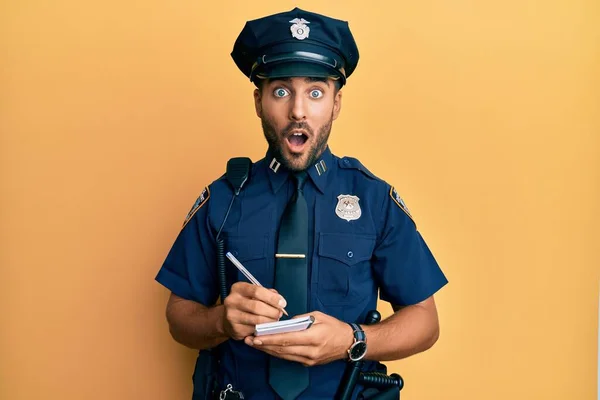 Hombre Hispano Guapo Vistiendo Uniforme Policía Escribiendo Multa Tráfico Asustado —  Fotos de Stock