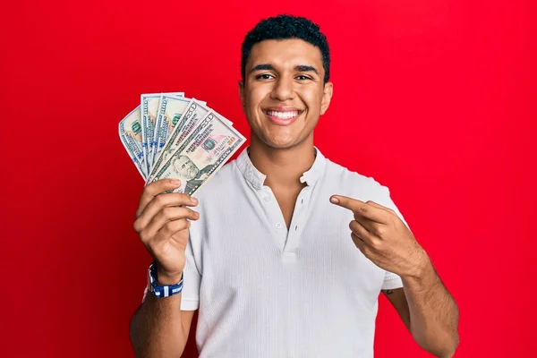 Joven Árabe Sosteniendo Dólares Sonriendo Feliz Señalando Con Mano Dedo —  Fotos de Stock